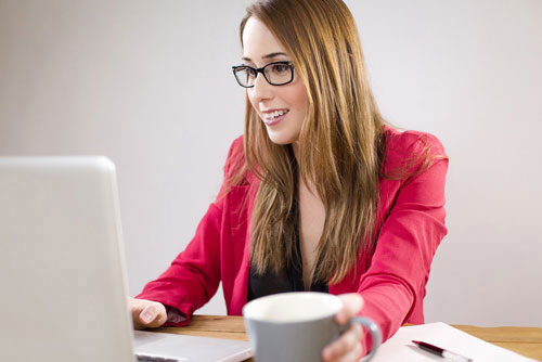 woman working at laptop with coffee