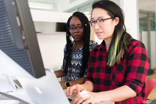 two women coding together collaboratively